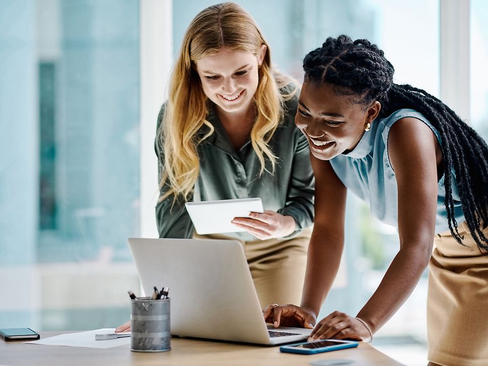 Zwei Frauen schauen interessiert auf einen Laptop