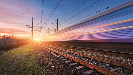 Zug fährt schnell in den Sonnenuntergang