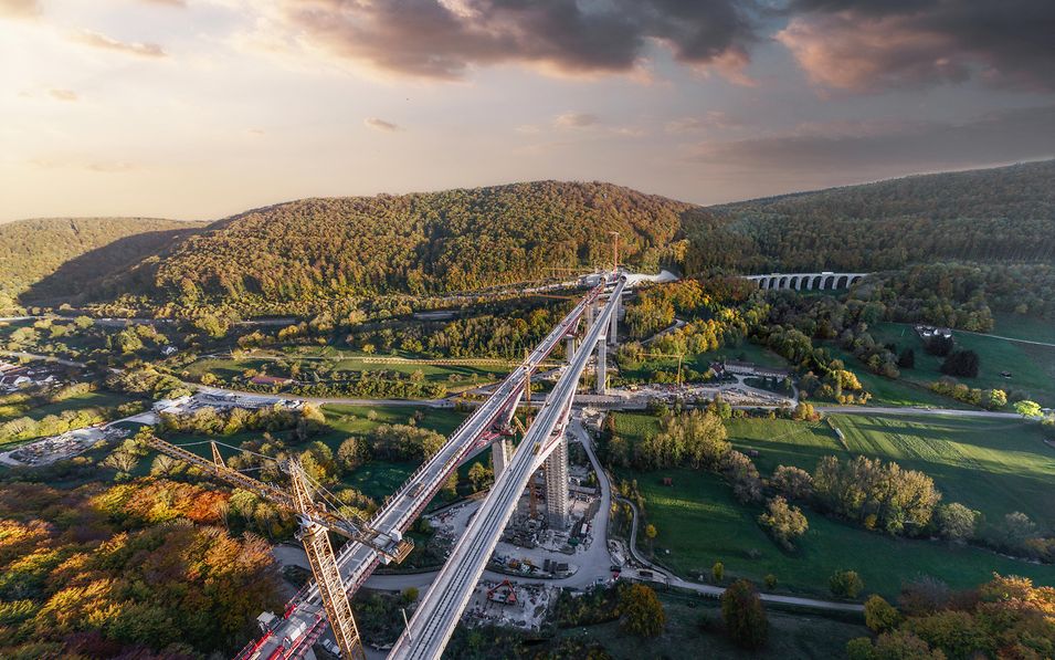 Panoramaansicht einer großen Eisenbahnbrücke über ein grünes Tal