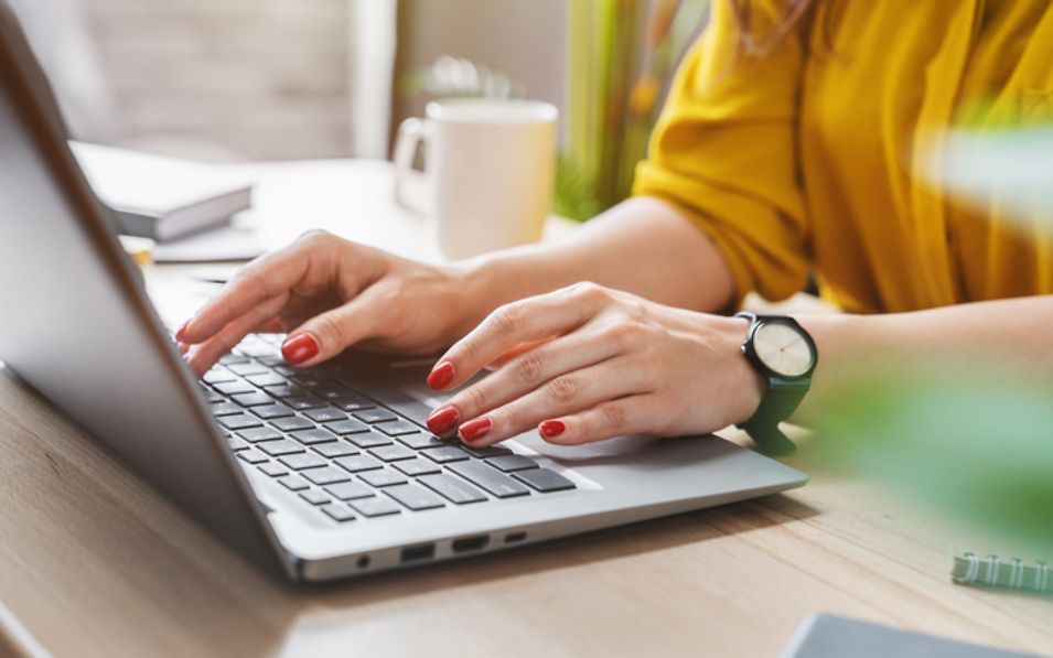 a woman typing on a laptop