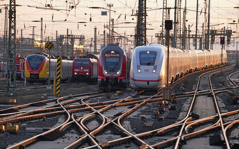 several train tracks with different trains of Deutsche Bahn on them
